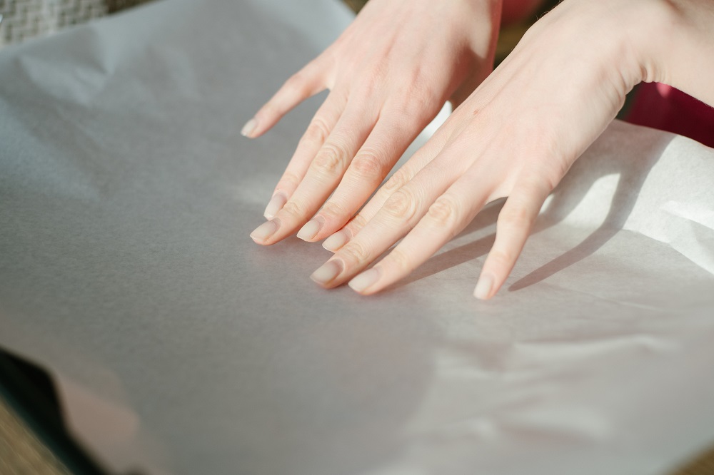 женские руки застилают противень пергаментом