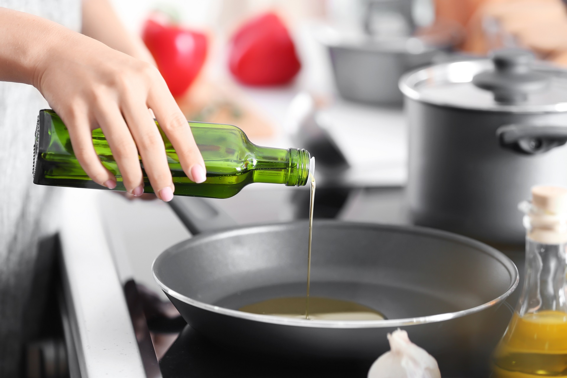 женщина наливает масло в сковороду