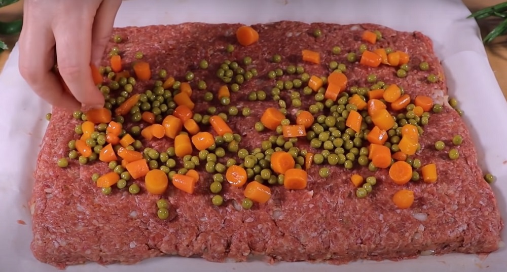 выложить консервированные овощи на мясной корж