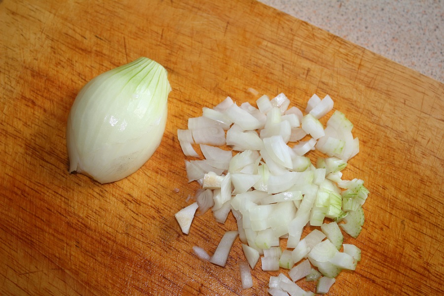 нарезанный лук на деревяннойдоске